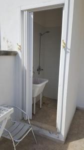 a white bathroom with a tub and a sink at Trilocale con doppio giardino 9 in Torre dell'Orso