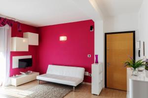 ポルト・トッレスにあるCasa Vacanze Porto Torresの白いソファと赤い壁のあるリビングルーム