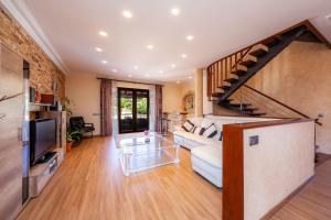 a living room with a white couch and a staircase at Villa Del Salto Uceda in Cala Santanyi