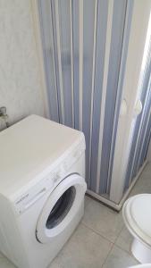 a washing machine in a bathroom with a toilet at Trilocale con doppio giardino 9 in Torre dell'Orso