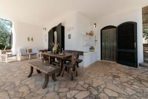 uma sala de jantar com uma mesa e um banco em Villa Azzurra em Corsano