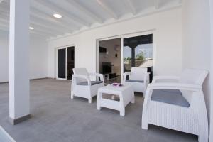 亞伊薩的住宿－Casa Mercedes，白色庭院配有白色的椅子和桌子