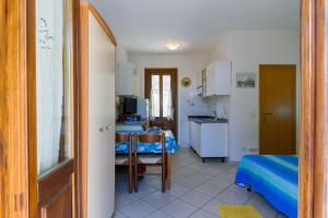 een kamer met een keuken met een tafel en een keuken bij Villino Beatrice Fetovaia in Campo nell'Elba