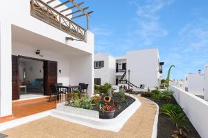 een wit huis met een balkon met een tafel bij Apartamento Los Morales in Puerto del Carmen