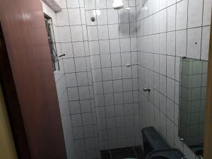 a bathroom with a toilet and a mirror at Hotel Dueto in São Bernardo do Campo