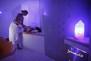 a woman standing in a bathroom with a man in a sink at Biohotel Grafenast in Pill
