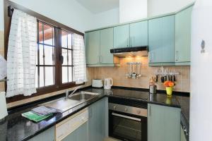 Una cocina con gabinetes azules y un fregadero. en Villa de la Paz, en Playa Blanca