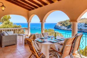 un patio con mesa, sillas y el océano en Villa Calima en Cala Romantica