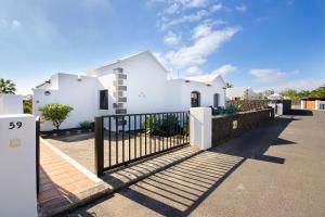 una casa blanca con una puerta delante de ella en Villa de la Paz, en Playa Blanca