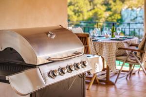 una parrilla en un patio con mesa y sillas en Villa Calima, en Cala Romántica