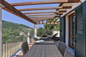 un patio con tavolo e sedie sul balcone. di Villetta Natura Casa B a Rio nellʼElba