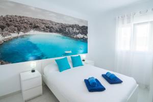 un dormitorio blanco con una gran imagen de playa en Villa Aday and Ixeia, en Cala Blanca