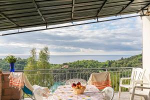 een tafel en stoelen op een balkon met uitzicht op de oceaan bij Simona Panorama in Fetovaia