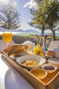 ein Tablett mit Essen auf einem Tisch und einem Glas Wein in der Unterkunft The Hamptons in Kaikoura