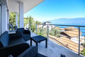 balcón con sillas y vistas al agua en Appartamento Luxury 2, en Pulciano