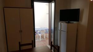 Zimmer mit einem TV auf dem Kühlschrank in der Unterkunft Bilocale 50 mt. dalla spiaggia 27 in Torre dell'Orso