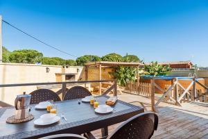 une table bleue et des chaises sur un balcon avec une table dans l'établissement Las tres hermanas, à Conil de la Frontera