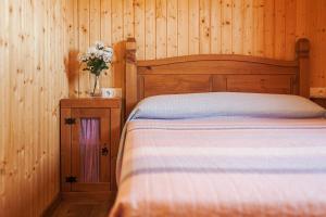 a bedroom with a bed and a vase of flowers at Las tres hermanas in Conil de la Frontera