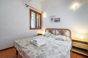 a bedroom with a bed and two night stands at Accu is Prezzus tipo H fronte mare in Villasimius