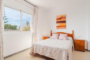 コニル・デ・ラ・フロンテーラにあるApartamento junto a la playa en el centroの白いベッドルーム(ベッド1台、窓付)