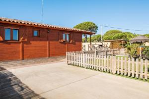 a wooden house with a white picket fence at Las tres hermanas in Conil de la Frontera