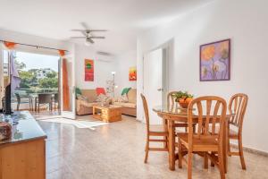 a kitchen and living room with a table and chairs at Bungalow Cala Dor 27 in Cala d´Or