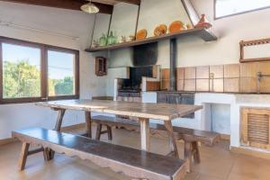 a large kitchen with a wooden table and benches at Can Poquet in Pollença