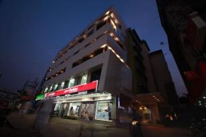 a tall building with lights on the side of it at Nexstay Asma Tower in Kozhikode