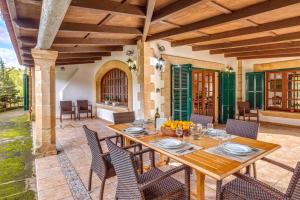 a wooden table and chairs on a patio at Villa Gran Voramar in Cala de Sant Vicent