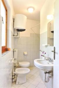 a white bathroom with a toilet and a sink at Appartamento Innamorata 2 in Palazzo
