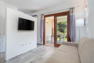 ブドーニにあるNuova Villetta a soli 200 mt dalla spiaggiaのソファと壁掛けテレビのあるリビングルーム
