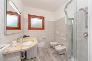 ブドーニにあるNuova Villetta a soli 200 mt dalla spiaggiaの洗面台、トイレ、シャワー付きのバスルーム +21枚の写真