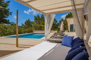 eine Außenterrasse mit einer Pergola und einem Pool in der Unterkunft Can Moustique in San Jose de sa Talaia