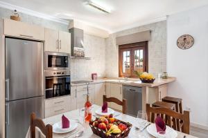Una cocina con una mesa con un bol de fruta encima. en Casa El Duque, en Vejer de la Frontera