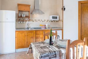 cocina con mesa y nevera blanca en Bungalows La Aceitera - Apartamento 1, en Zahora