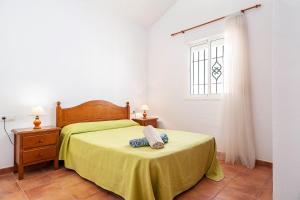 a bedroom with a bed with a yellow bedspread and a window at Casa Palillero - Sólo Familias in Conil de la Frontera +19 photos