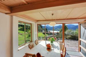 a dining room with a table and chairs and windows at Chalet am Brand in Tegernsee