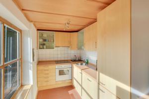 eine Küche mit Holzschränken und einem Fenster in der Unterkunft Chalet am Brand in Tegernsee