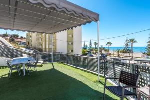 balcón con mesa y sillas y la playa en Apartamento a pie de playa, en Benajarafe