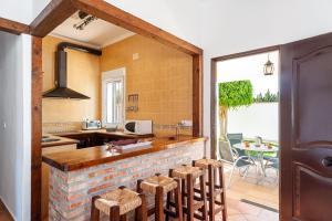 una cocina con encimera con taburetes. en Chalet Rancapinos, en Conil de la Frontera