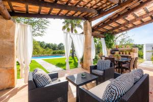 eine Terrasse mit Stühlen, einem Tisch und einer Terrasse in der Unterkunft Sa Creu De Saume in Artá