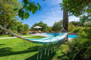 eine Hängematte im Garten neben einem Pool in der Unterkunft Sa Creu De Saume in Artá