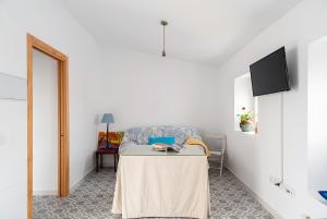a living room with a table and a chair at Apartamento Lola - Sólo Familias in Conil de la Frontera
