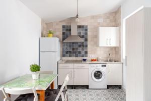 a kitchen with a white refrigerator and a washing machine at Apartamento Lola - Sólo Familias in Conil de la Frontera