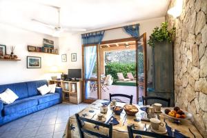 - un salon avec une table et un canapé bleu dans l'établissement Villa Vanna, à Villasimius