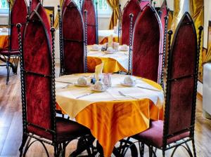 a dining room with two tables and red chairs at Hotel Puntijar in Zagreb