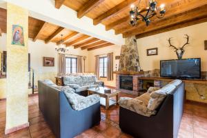 a living room with couches and a fireplace at Casa Rural Loma El Letrao in Almogía