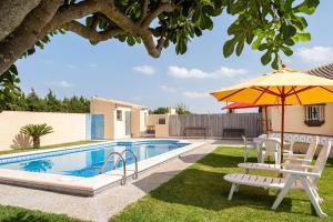 a pool with chairs and an umbrella next to a house at Solo Para Familias - Camino del Pozo La Boyal in Chiclana de la Frontera