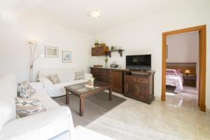 a living room with a couch and a tv at S'ancora in Port de Soller