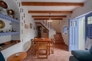 a kitchen and living room with a table and chairs at Casa Rural El Tesillo in Canillas de Aceituno